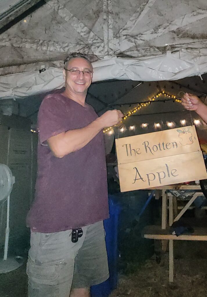 Mike hanging sign for The Rotten Apple